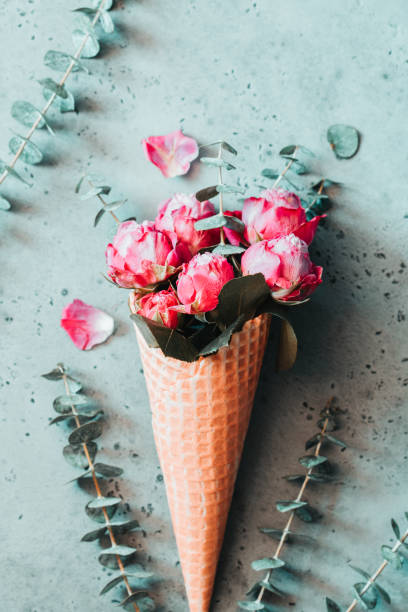 istock Creative minimalist flat lay with waffle cone and pink roses inside it on a white background. The concept of spring and Valentines day. 1094780904