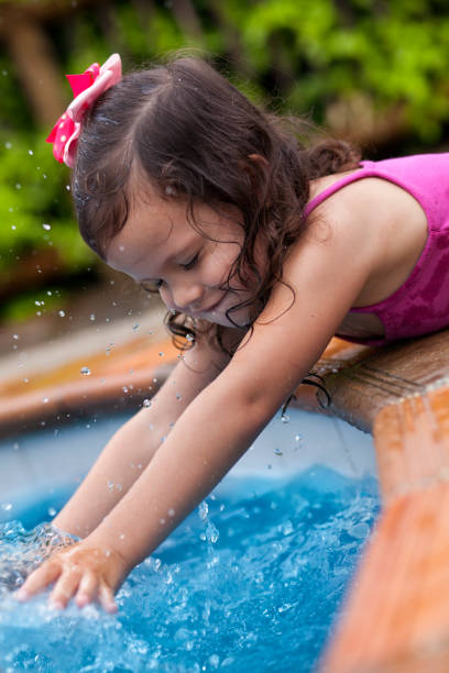 istock Happy latin girl playing in the pool 1094780980