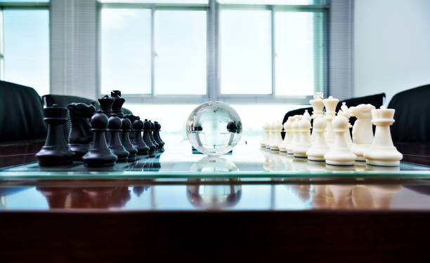 istock Chess pieces and glass earth globe on the conference table 1094781176