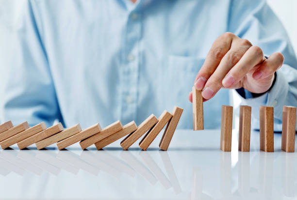 istock Businessman hand pick up one domino 1094782600
