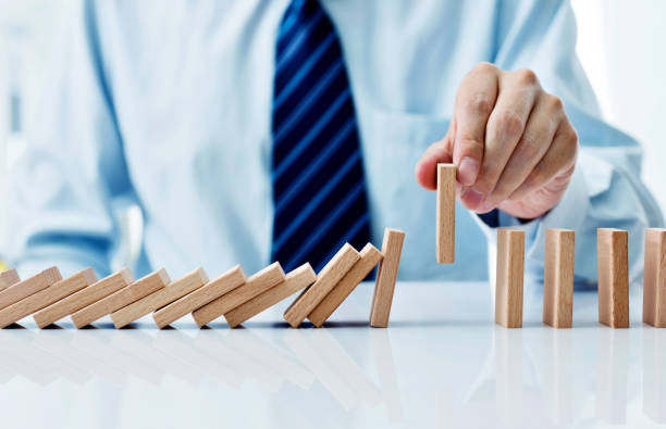 istock Businessman hand pick up one domino 1094782608