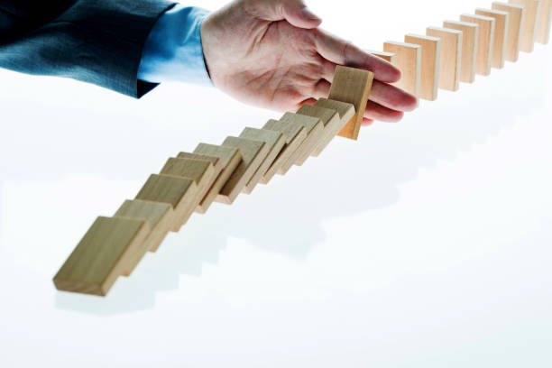 istock Businessman hand stop domino effect 1094782654