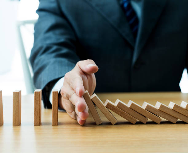 istock Businessman hand stopping falling blocks on table 1094782708