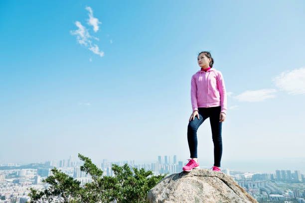 istock Woman standing on the mountain peak rock 1094785684