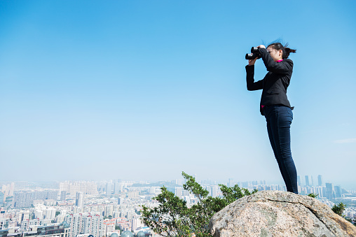 Businesswoman looking scenery with binocular.