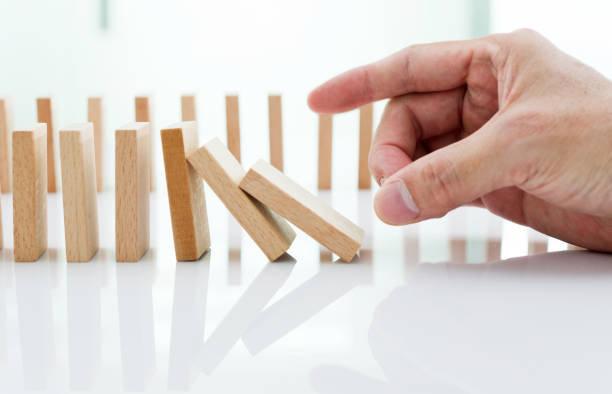 istock Man hand pushing domino pieces 1094790050