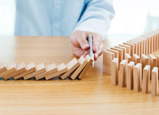 istock Businessman hand holding a pen stop domino effect 1094790160