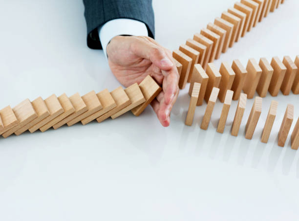 istock Businessman hand stopping falling blocks on table 1094790212