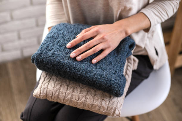 istock Woman's hands holding knitted clothes. Close up. 1094791706