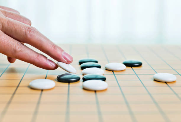 istock Man hand put go game pieces on the board 1094795388