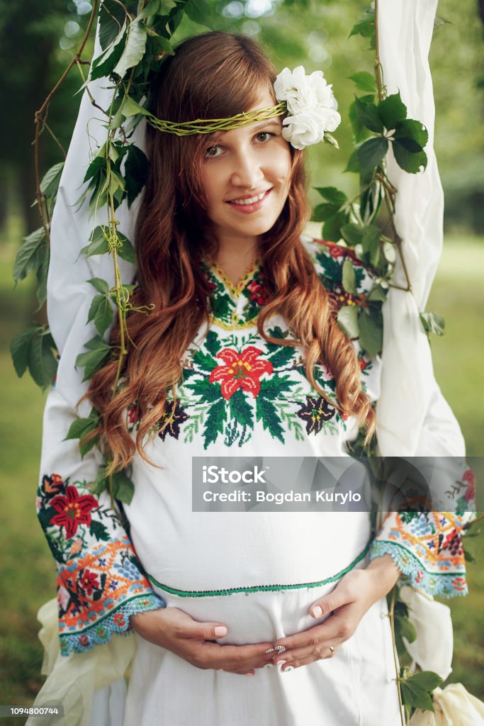 Hermosa Mujer Embarazada En El Tradicional Vestido Blanco En Columpio En Primer Plano Del Parque Momento Tierno De La Maternidad Foto de stock y más banco de imágenes de Adulto - iStock Hermosa Mujer Embarazada En El Tradicional Vestido Blanco En Columpio En Primer Plano Del Parque Momento Tierno De La Maternidad Foto de stock y más banco de imágenes de Adulto - iStock