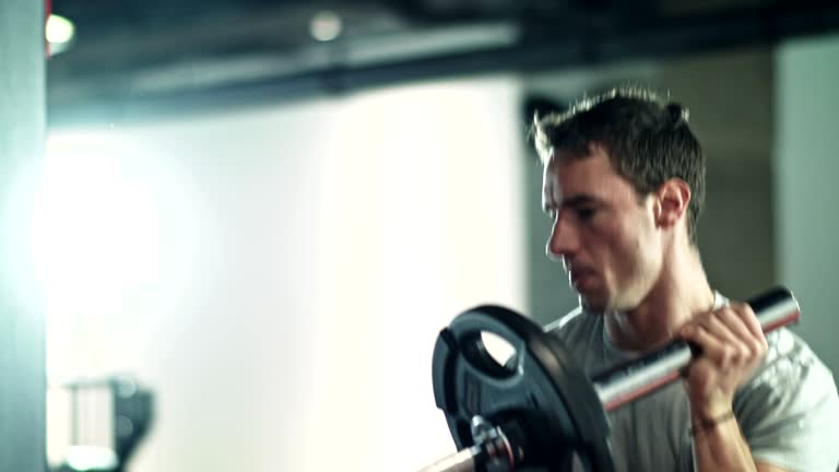 Man doing Single-arm Landmine Squat-to-Press exercise