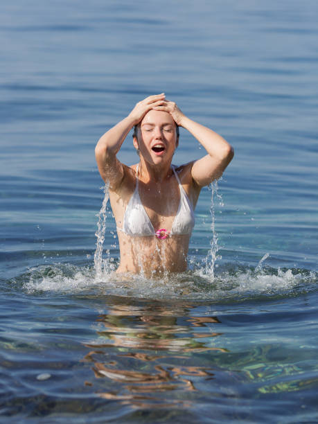 istock Girl  in bikini playing in seawater 1094813582