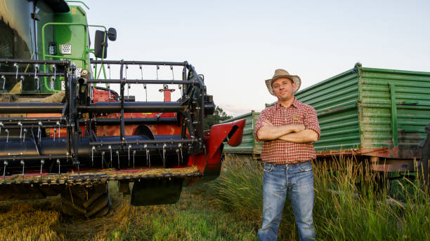 istock Man standing near combine-harvester 1094813706