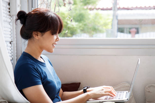 istock Young Asian woman using laptop computer notebook at coffee shop. e-learning concept - Image. 1094814078