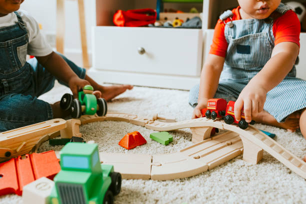 little children playing with a railroad train toy - african ethnicity brother ethnic little boys imagens e fotografias de stock