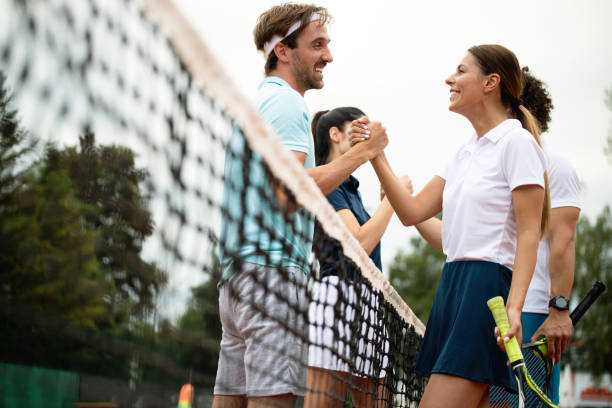 forma personas felices jugar juntos al tenis. concepto de deporte - tennis couple women men fotografías e imágenes de stock