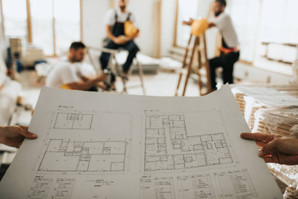 istock Close up of unrecognizable architect examining blueprints at construction site. 1094819584