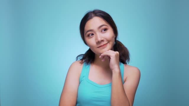 Woman thinking and having an idea on isolated blue background 4k