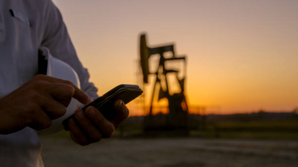 Close up of smart phone Close up of smart phone against pumpjack oil field stock pictures, royalty-free photos & images