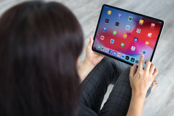 chiang mai, tailândia - 3 de janeiro de 2019: ipad pro uma nova versão do tablet da apple. mulher usando o novo ipad de apple de 12,9 polegadas pro 2018, swiping para a tela inicial ou tocar o ícone do aplicativo. - ipad 3 - fotografias e filmes do acervo