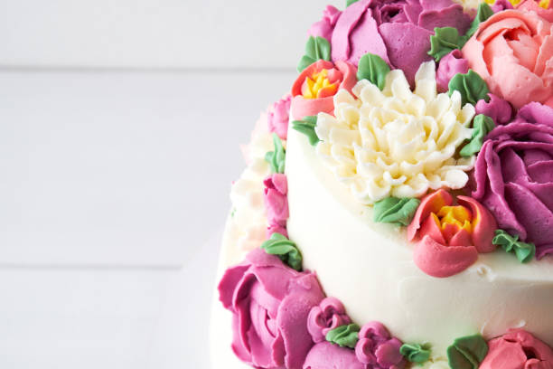 istock Two-tiered white wedding cake decorated with color cream flowers 1094821284