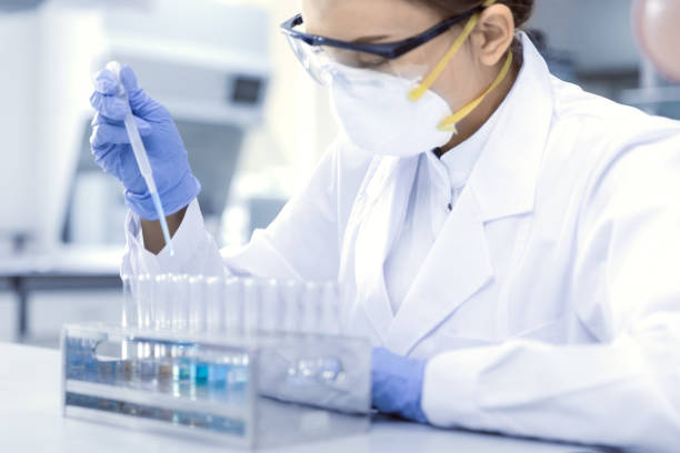 joven científico femenino trabaja en el laboratorio - medical sample fotografías e imágenes de stock