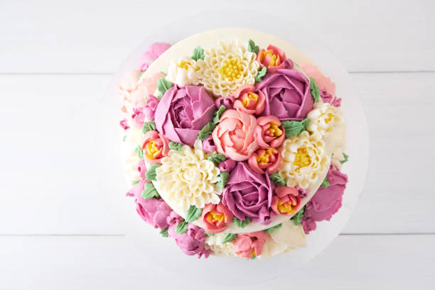 istock Two-tiered white wedding cake decorated with color cream flowers 1094822354