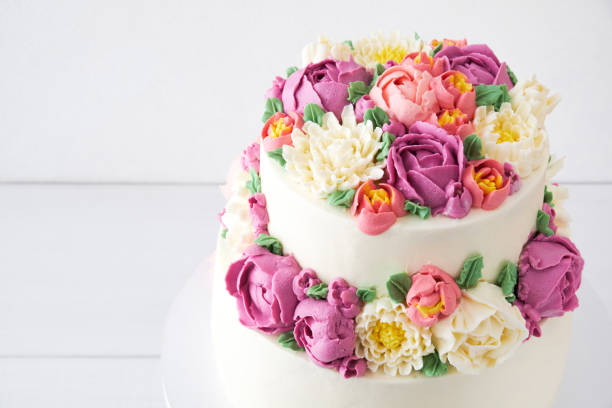 2 층 화이트 웨딩 케이크 크림 색 꽃 장식 - icing cake multi colored weddings 뉴스 사진 이미지