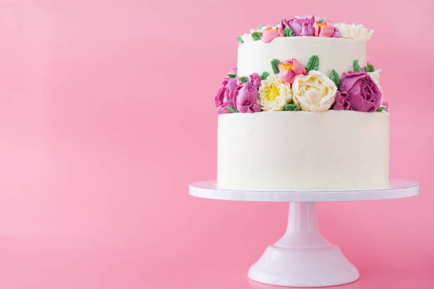 istock Two-tiered white wedding cake decorated with color cream flowers 1094822458