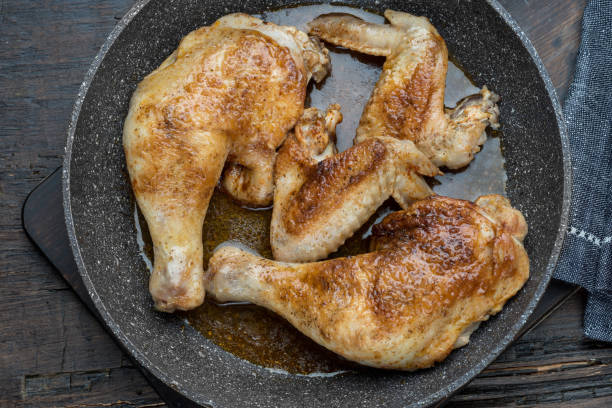 istock Grilled chicken legs with spices on wooden background 1094823294