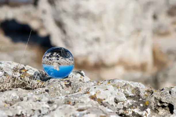 Photo of Upside down landscape of Pobiti Kamani, The Stone Forest Natural Reserve near Varna in Bulgaria, Eastern Europe - reflection in a lens ball - selective focus, space for text