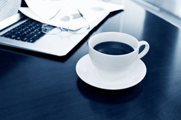 Coffee cup and office supplies on table.