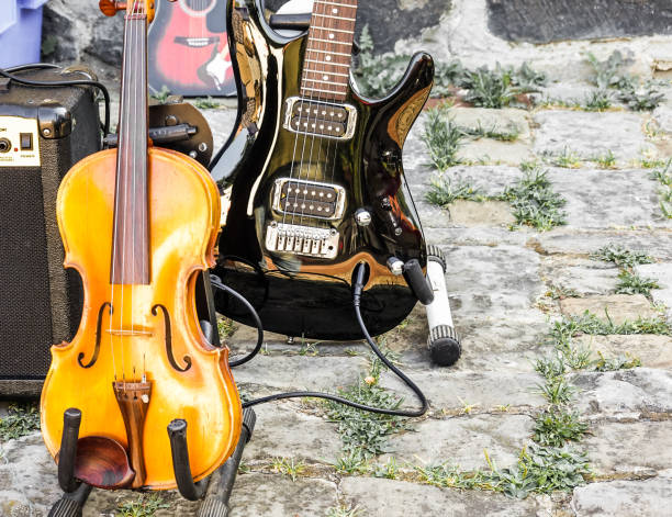 nahaufnahme von einer geige und einem schwarz lackierten e-gitarre auf einem flohmarkt - weight training audio stock-fotos und bilder