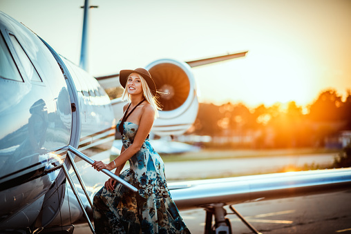 Hermosa chica rubia y abordar un avión privado al atardecer photo