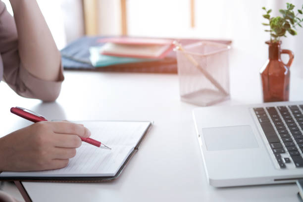 istock young woman studying while sitting at the table with laptop computer and notebook during lesson in classroom. 1094835332