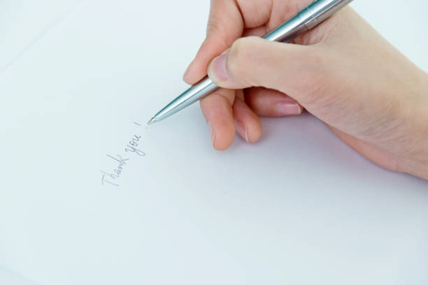 Woman writing thank you on paper.