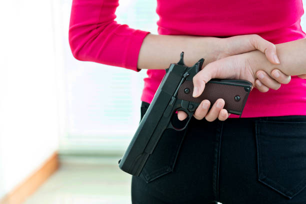 istock A gun behind woman back 1094837782