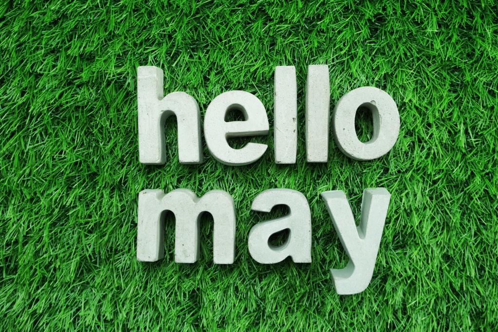 Hello May made from concrete alphabet top view on green grass