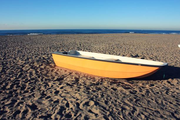 istock small fishing boat all alone, beached on the winter beach 1094838440