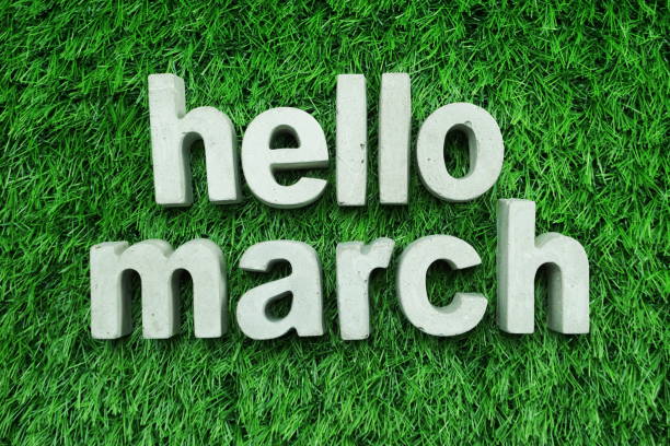 istock Hello March made from concrete alphabet top view on green grass 1094841146