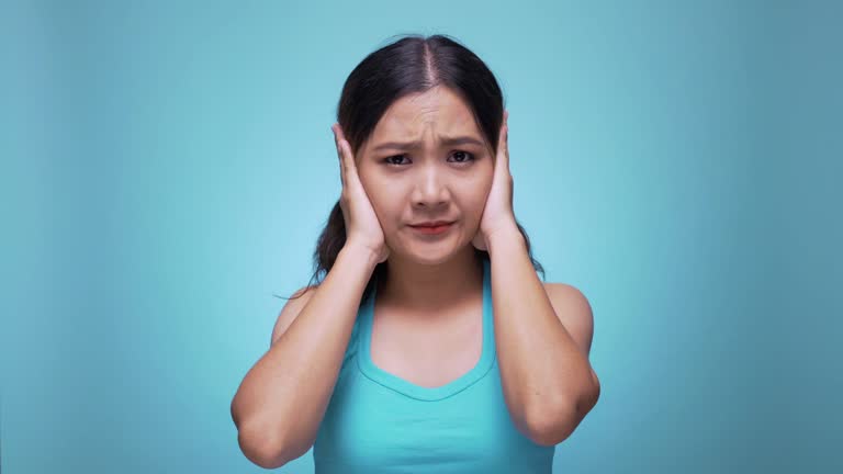 Unhappy woman closing ears on isolated blue background 4k