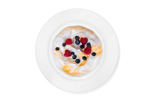 Top view on a white serving plate with a meringue cake on the white background. Concept. Isolated