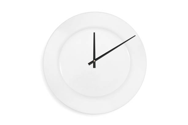 istock Top view of a empty serving plate as a clock with arrows on the white background. Concept. Isolated 1094846774