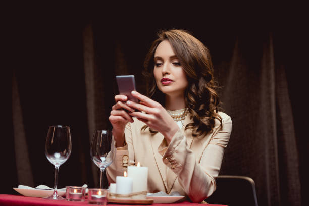 istock beautiful woman sitting at table and using smartphone in restaurant 1094846892