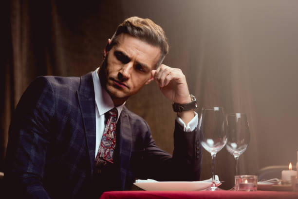 istock handsome pensive man sitting at table and waiting for someone in restaurant 1094846922