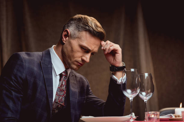 istock handsome pensive man sitting at table and waiting for someone in restaurant 1094847012