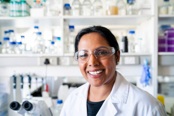 ritratto di ricercatore maturo sorridente in laboratorio - research smiling scientist women foto e immagini stock