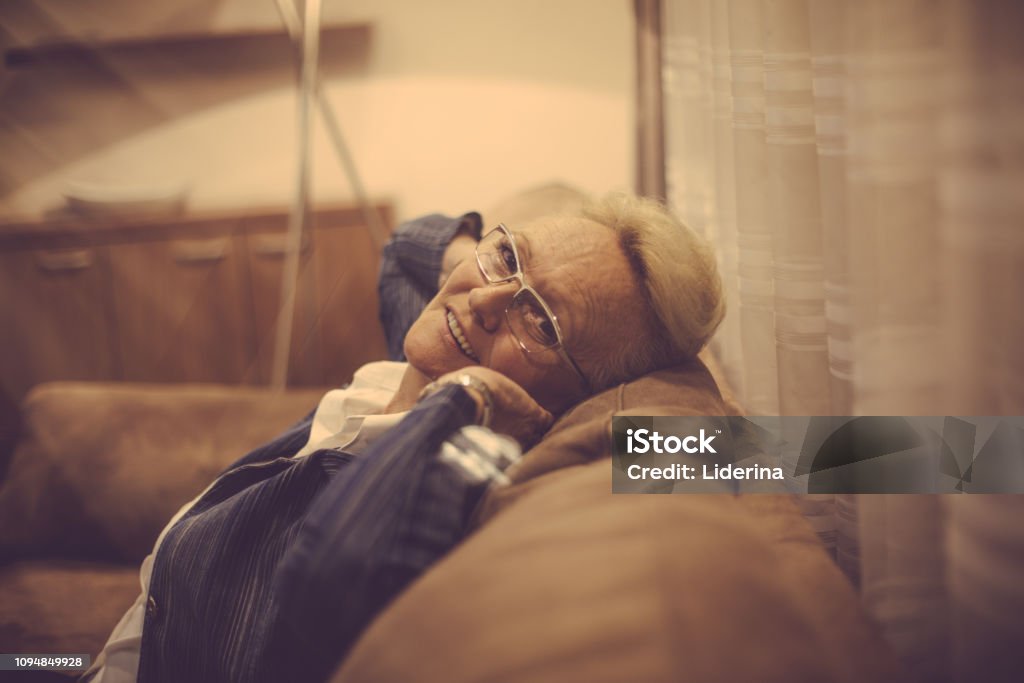 I like evening relaxation. I like evening relaxation. Smiling senior woman at home. Close up. Living Room Stock Photo