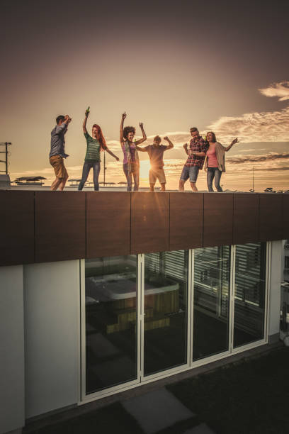 istock Large group of young happy people having fun while dancing on rooftop at sunset. 1094858116